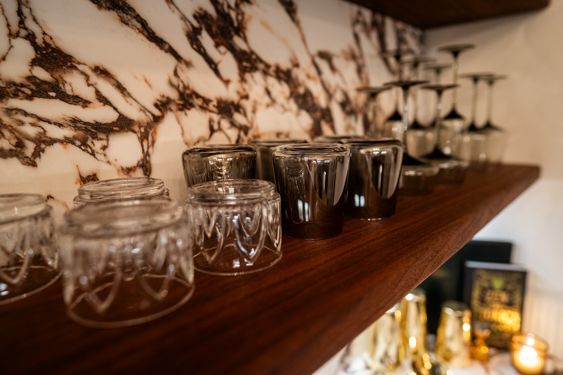 Glassware on the bar's marble-backed shelf